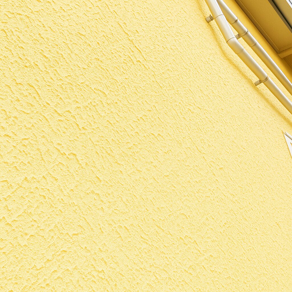 ジョリパッド外壁をうすい黄色に塗装した仕上がりの写真。凹凸がはっきりとした美しい外壁表面